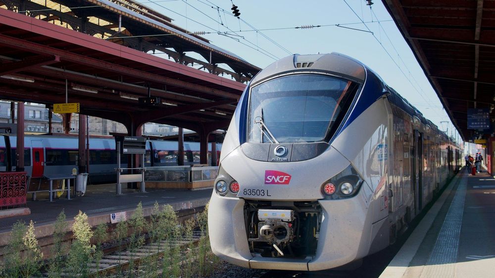 An SNCF train waiting at a sunlit station platform in France