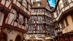 Half-timbered houses in Colmar's old town decorated for Christmas, with stars and garlands on the facades