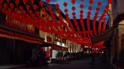Hundreds of red paper lanterns strung over an old town street at dusk for Lunar New Year